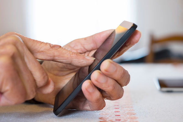 woman's hand dialing a number on a cell phone